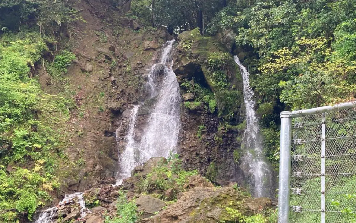 緑に囲まれた崖から落ちる滝